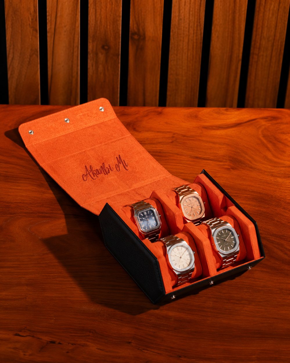 Orange LWR 4-slot watch roll open with four watches and the name Akanbi Mi engraved inside